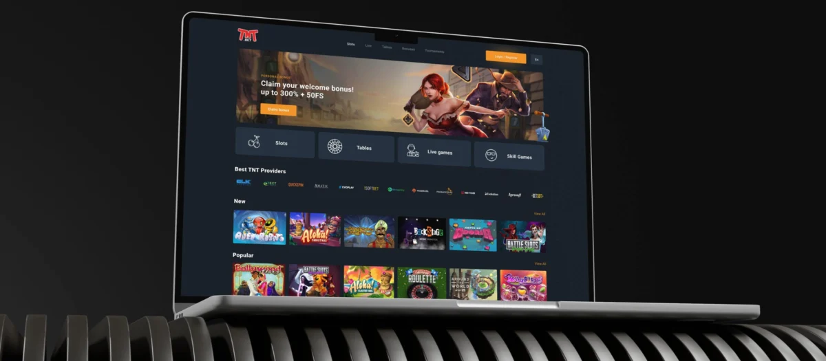 TNTBet lobby on a laptop screen with the welcome banner above the game rows